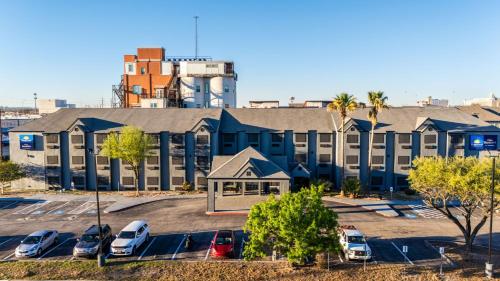 a large building with cars parked in a parking lot at Day Inn by Wyndham San Antonio Downtown in San Antonio