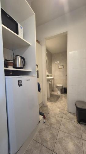 a kitchen with a refrigerator and a room with a toilet at Solar Andino Inn in San Carlos de Bariloche