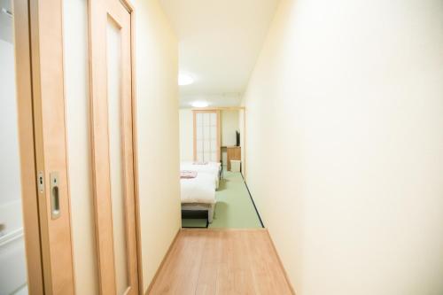 a hallway leading to a bedroom with a bed at Matsuya hotel in Myoko