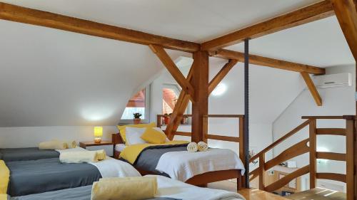 two beds in a room with wooden beams at Peaceful Family Apartments near Terme Čatež in Čatež ob Savi