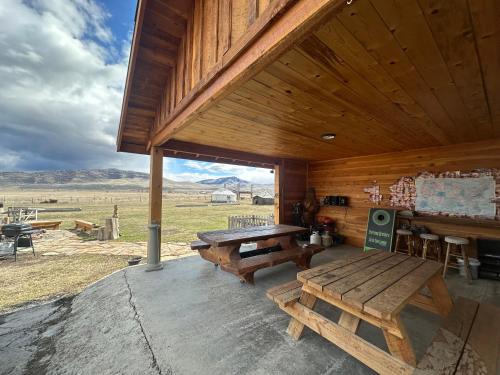 a wooden cabin with a bench and a table at Cabin 1 The Glacier in Hot Springs