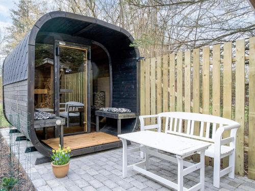 a black building with two benches and a table at 6 person holiday home in Gørlev in Gørlev