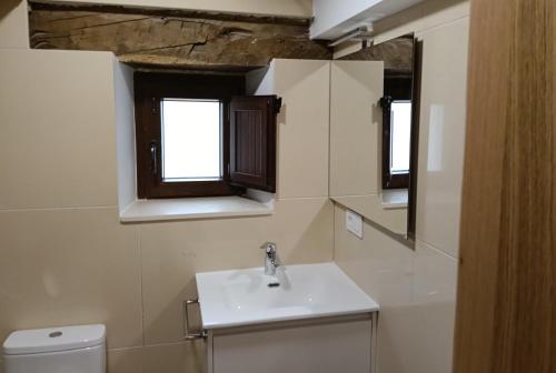 a bathroom with a sink and two windows at ALOJAMIENTO MONTE EDILLA Naturaleza, Confort y Recarga Eléctrica in Quintana de los Prados