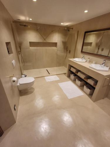 a bathroom with a toilet and two sinks at les gites de pietra rossa in Bastia