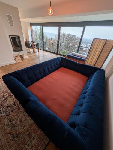 a large blue couch with a red cushion in a living room at Large city apartment with beautiful views in Marburg an der Lahn