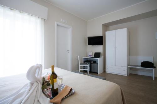 a bedroom with a bed with a bottle of champagne at Hotel Costazzurra Museum & Spa in San Leone