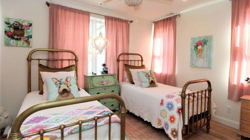 two twin beds in a bedroom with pink curtains at 12 Pearls in Cape May Point