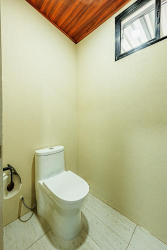a bathroom with a white toilet and a window at Mountain Whisper in Tilarán