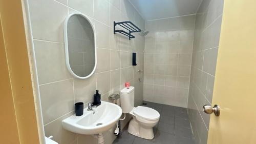 a bathroom with a sink and a toilet and a mirror at Zahran Homestay in Papar