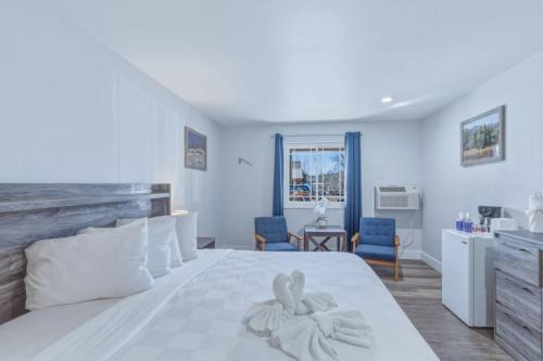 a bedroom with a white bed with a towel on it at RiverWalk Inn in Pagosa Springs