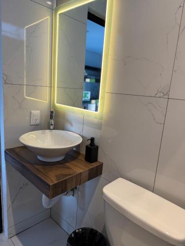 a white bathroom with a sink and a mirror at Loft with Private Terrace in Tepic