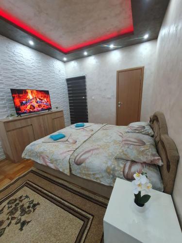 a bedroom with a large bed and a tv at Trend Lux Obrenovac, sa parkingom in Obrenovac