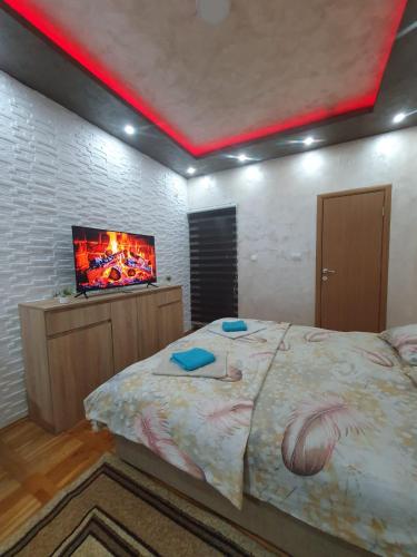 a bedroom with a bed with a tv on the wall at Trend Lux Obrenovac, sa parkingom in Obrenovac