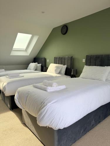 two beds in a bedroom with a skylight at The Alcove Retreat in Bristol