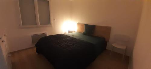 a small bedroom with a bed and a lamp at Chambre privée villa montelimar in Montélimar
