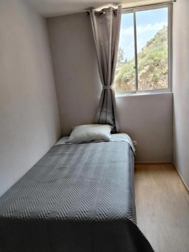 a bed in a small room with a window at Cusi Wasi AQP in Arequipa