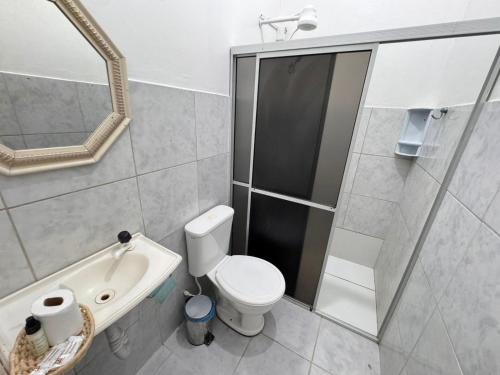 a bathroom with a toilet and a shower and a sink at Bru&Mar Pousada in Parnaíba