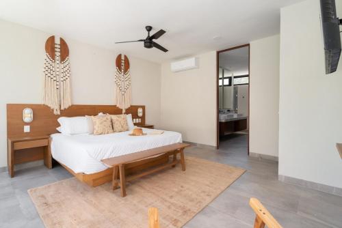 a bedroom with a bed and a ceiling fan at Casa Kaybe in Tulum