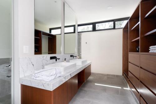 a bathroom with two sinks and a large mirror at Casa Kaybe in Tulum