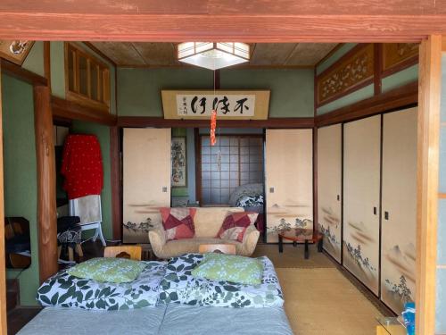 a room with a bed and a couch in it at Inn Omishima in Imabari