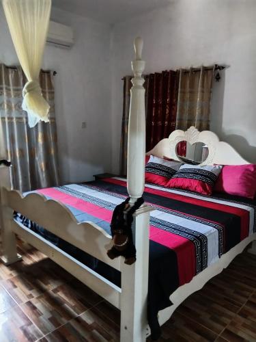 a bedroom with a bed with a white bed frame at The Gibson's Palace in Ocho Rios