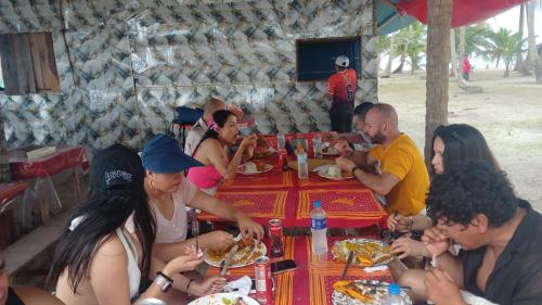 a group of people sitting around a table eating food at CABAÑA ARRIYALADUP San-Blas in Arritupo Número Dos