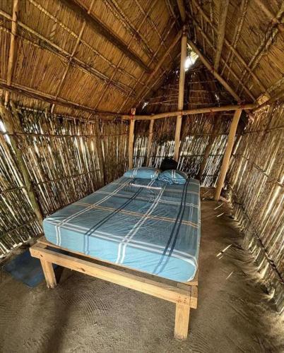a bed in a thatch hut with a mattress at CABAÑA ARRIYALADUP San-Blas in Arritupo Número Dos