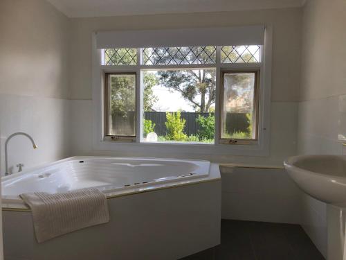 a white bathroom with a tub and a sink at Clare to Spalding character escape in Spalding