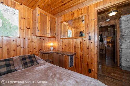 a bedroom with a bed in a wooden cabin at Breezy Woods - Tobermory Waterfront in Tobermory