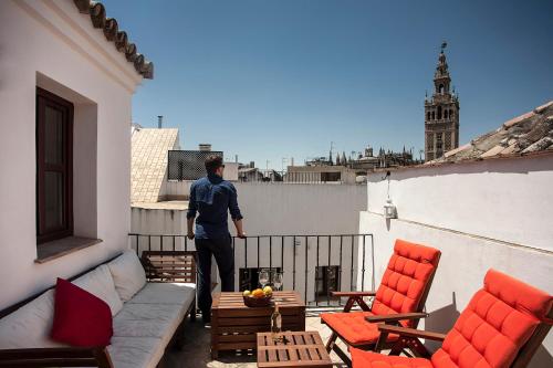 un hombre parado en el balcón de un edificio en Angeles House, en Sevilla