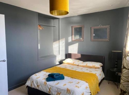 a bedroom with a bed with a yellow blanket on it at Central location Sea view in Hastings
