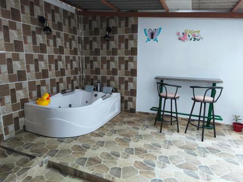 a bathroom with a tub and a table and two stools at Casa Aranza in Cartagena de Indias