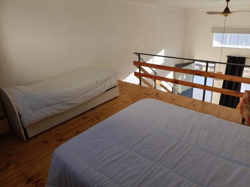 a bedroom with two beds and a stair case at Palmeras al sol in San Pedro