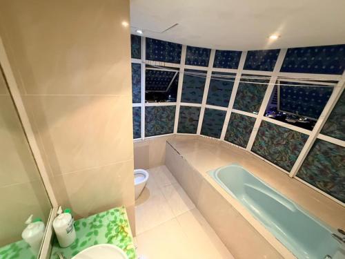 a bathroom with a tub and a toilet at Klcc Cozy Unit in Kuala Lumpur