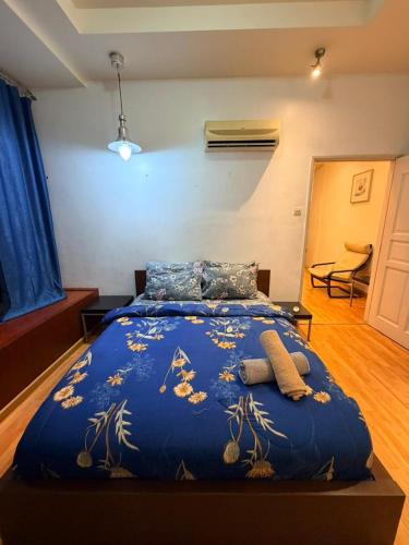 a large bed in a room with a blue comforter at Klcc Cozy Unit in Kuala Lumpur