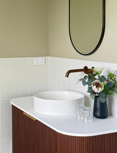 a bathroom with a sink and a vase of flowers at Robertson Public House and Kitchen in Robertson