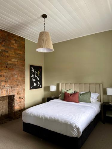 a bedroom with a large bed and a fireplace at Robertson Public House and Kitchen in Robertson