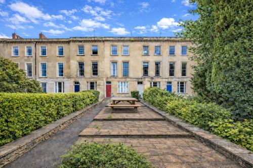 a building with a picnic table in front of it at STR8BS8 2-Bedroom Penthouse, Clifton, Parking, Garden & City Views in Bristol