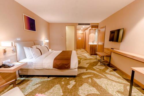 a hotel room with a large bed and a television at Holiday Inn Ulaanbaatar by IHG in Ulaanbaatar