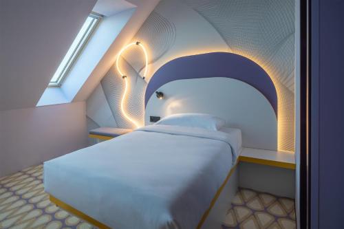a bedroom with a white bed with an archway at Prize by Radisson, Gdansk in Gdańsk