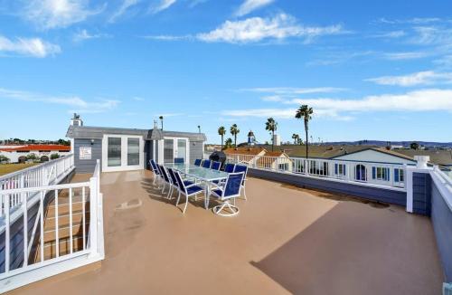 a deck with blue chairs and a table on a building at Rooftop Deck with Stunning 360 Beach Views condo in Newport Beach