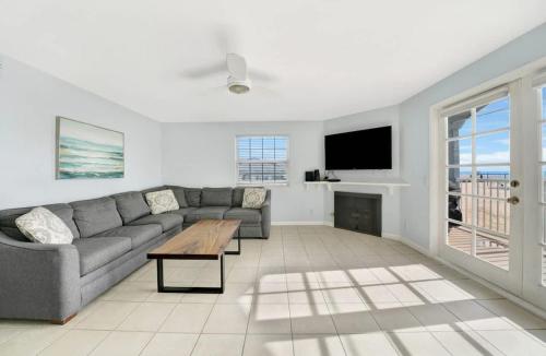 a living room with a couch and a table and a tv at Ocean and Scenic Beach Views From Deck apts in Newport Beach