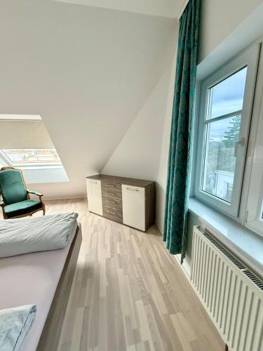 a attic room with a bed and a window at Leo Stay in Leopoldsdorf