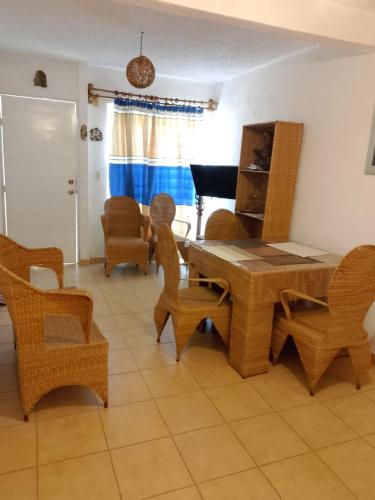 a living room with a table and chairs and a piano at Casa Tortuga in Ixtapa
