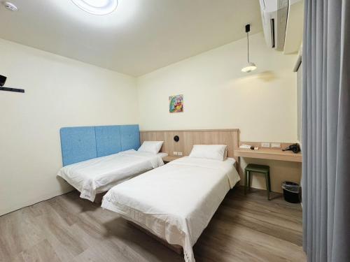 a hospital room with two beds and a desk at 海洋星空民宿 in Magong
