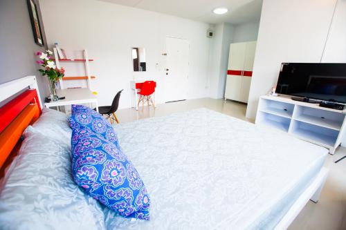 a bedroom with a large bed with blue pillows on it at Room 9 Residence in Pluak Daeng