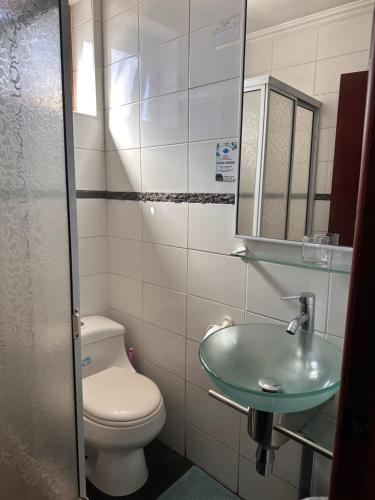 a bathroom with a toilet and a sink at Hotel Bello, Andrés Bello 1166 in Temuco