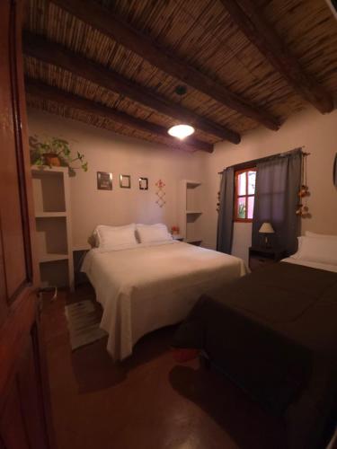 a bedroom with a large white bed and a window at Tierra Norte - Cabañas in Tilcara