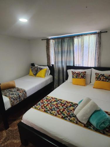 a room with two beds and a window at Alojamiento el jardin in Filandia