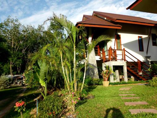 a house with a palm tree in front of it at Seagull Villa in Ko Lanta